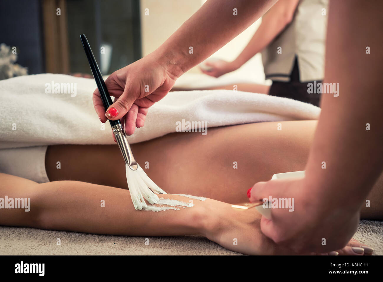 Asian terapista applicando il ringiovanimento del balsamo di umidità a bellezza ce Foto Stock