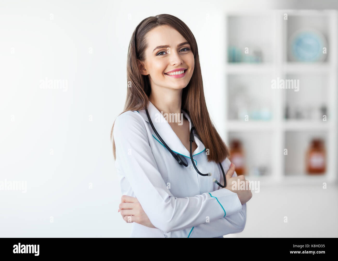 Ritratto di fiducia medico sorridente con le braccia incrociate in ospedale Foto Stock