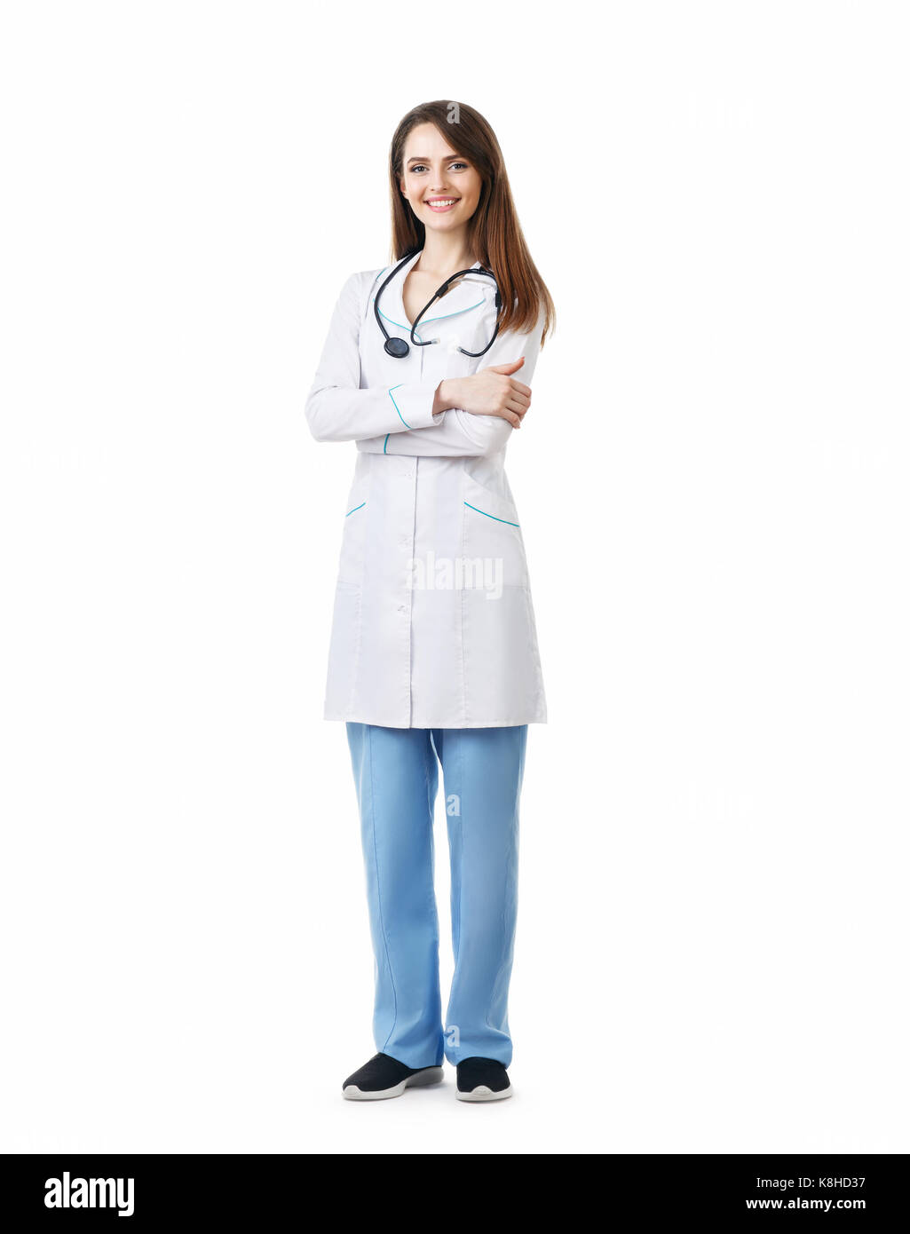 A piena lunghezza ritratto della bella medico sorridente con le braccia incrociate isolato su sfondo bianco Foto Stock