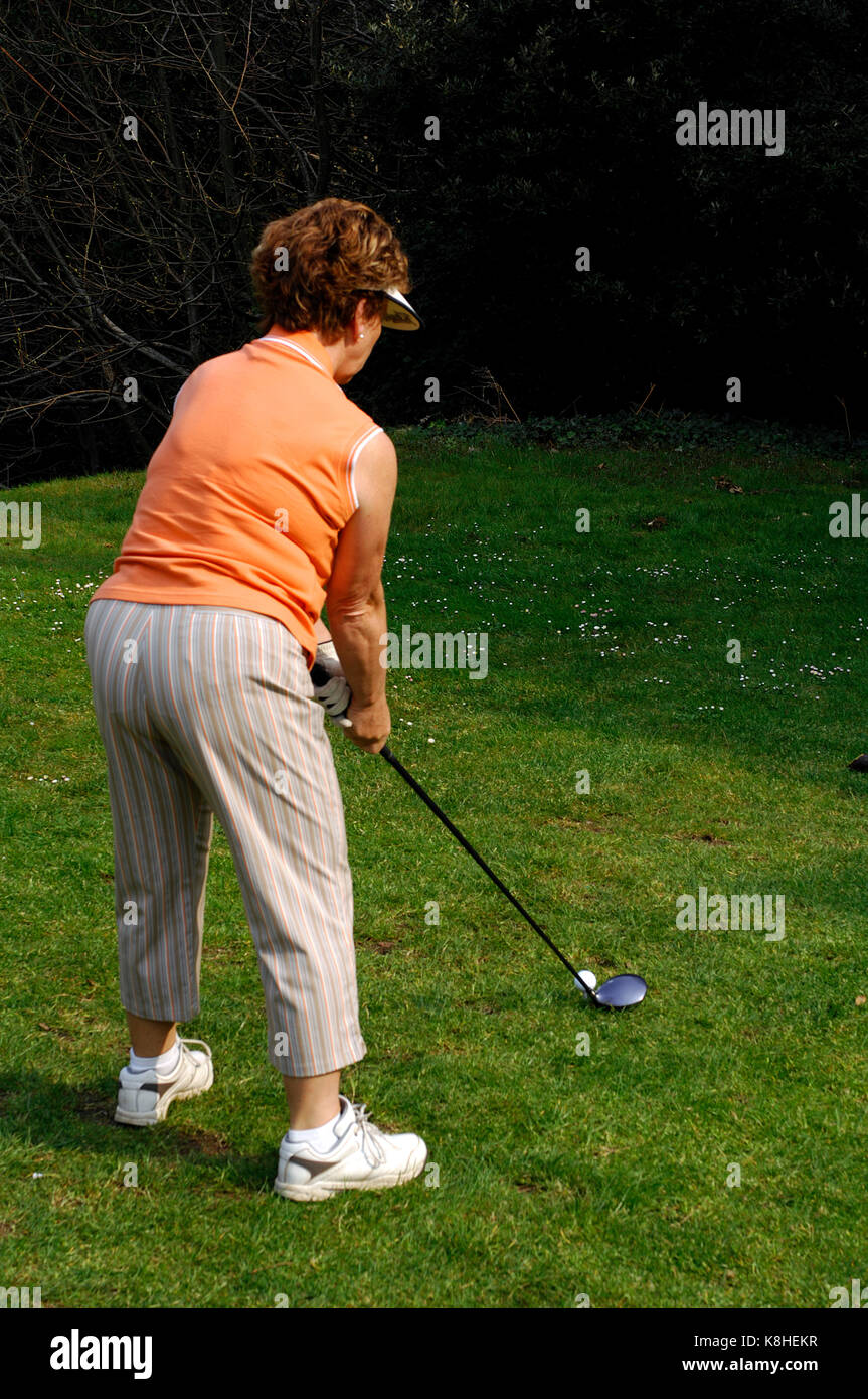 Una vecchia signora giocare un colpo in un round di golf. giocando a golf in pensione o più avanti nella vita che partecipano a sport e rimanendo attivo, Foto Stock