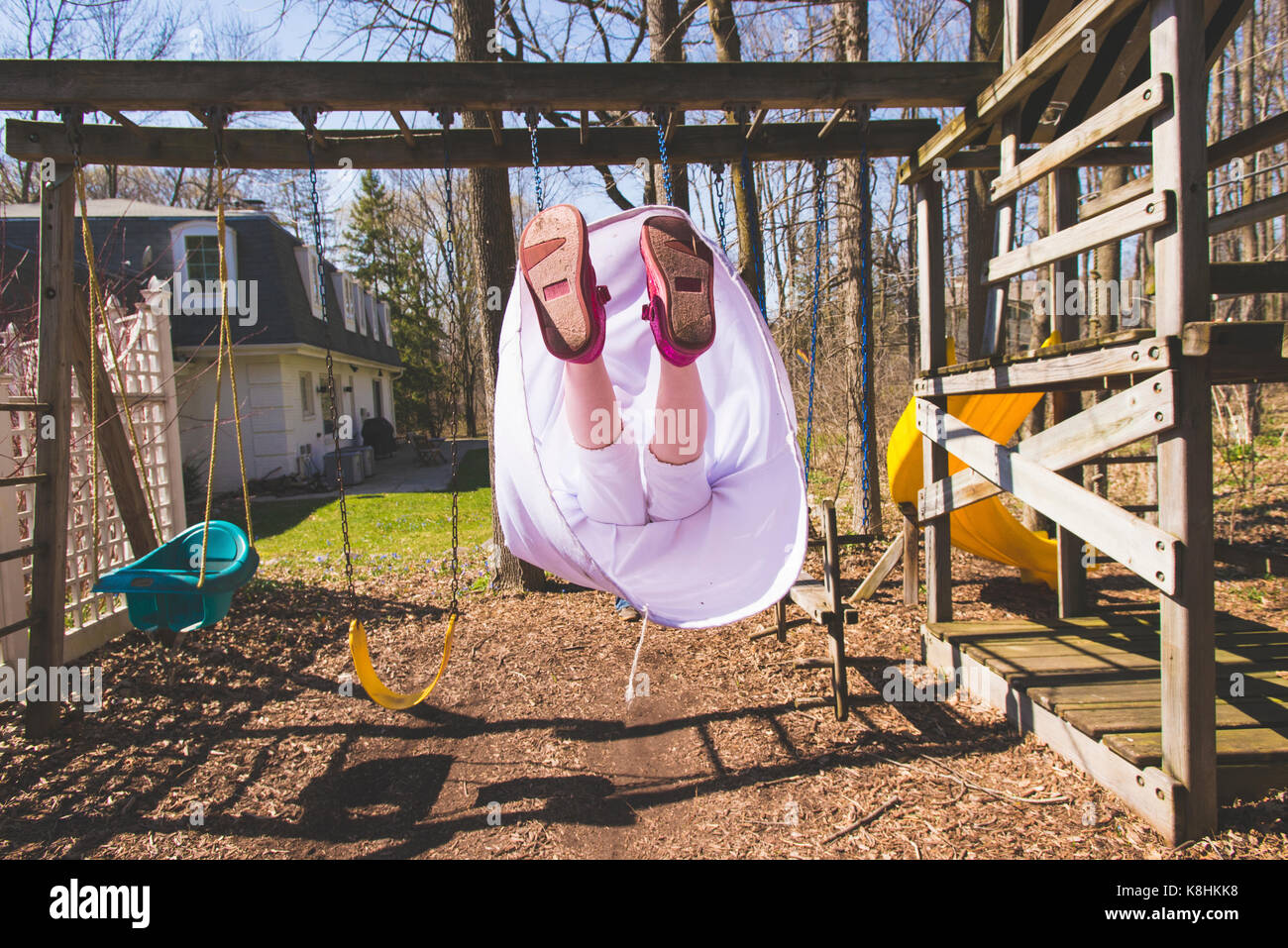 Sezione bassa della ragazza swinging presso il parco giochi in estate Foto Stock