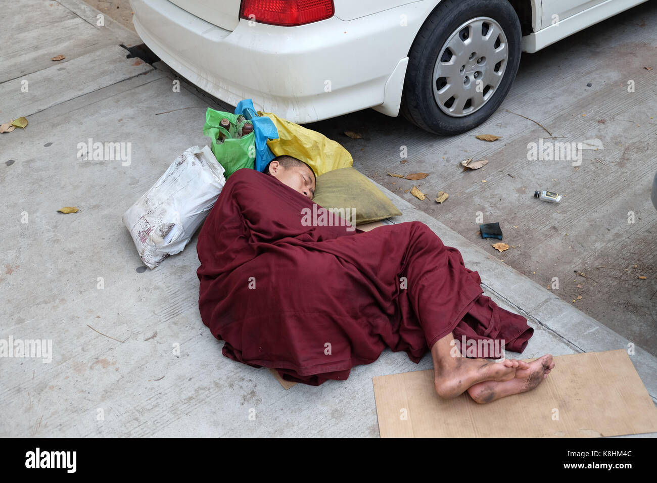 La birmania, myanmar: Monk dormire in una strada di Rangoon Foto Stock