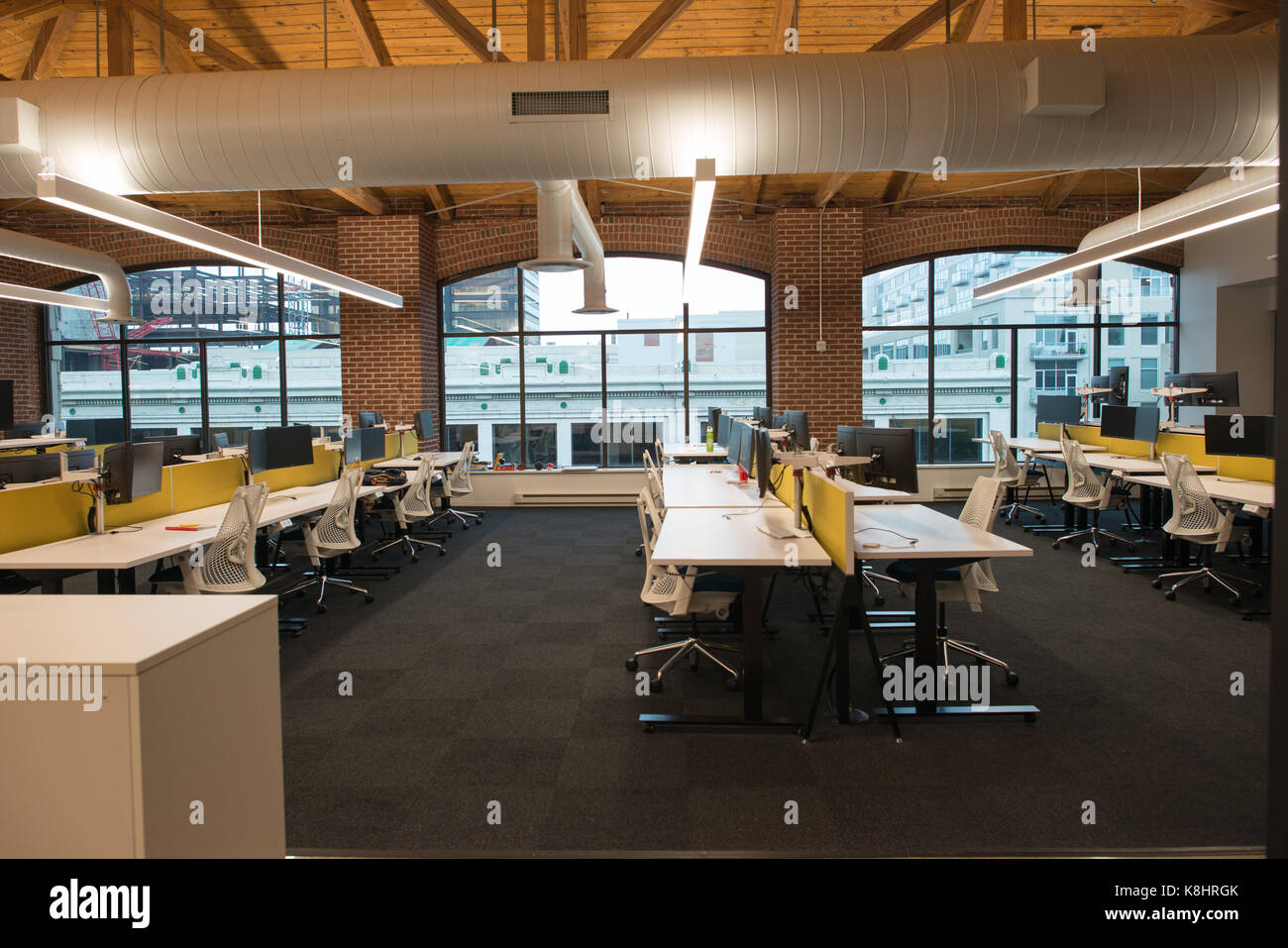 Moderno concetto aperto loft spazio per uffici con grandi finestre e luce naturale e un layout per incoraggiare la collaborazione, creatività e innovazione Foto Stock