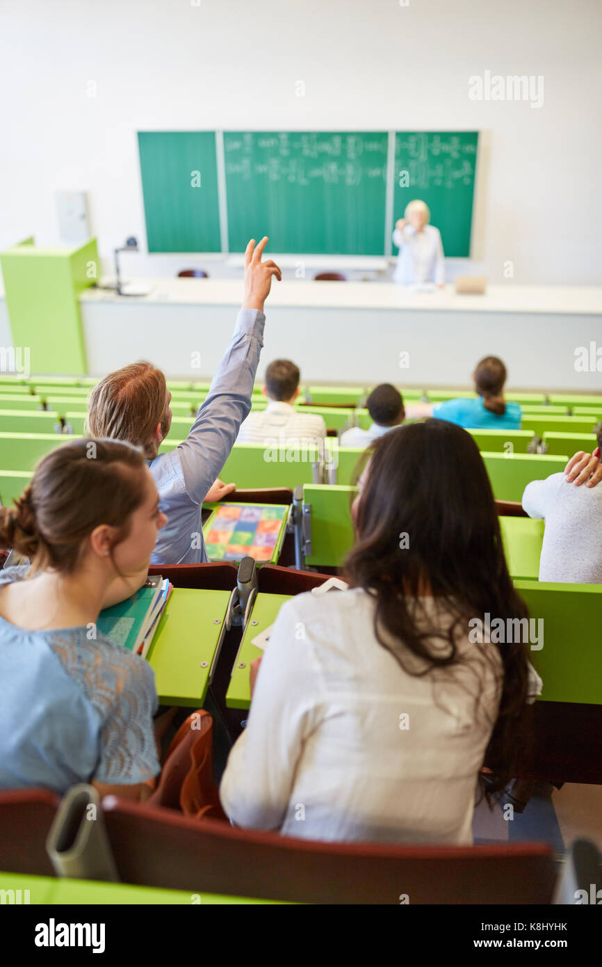 Studente di alzare la mano con diligenza nella lezione universitaria Foto Stock