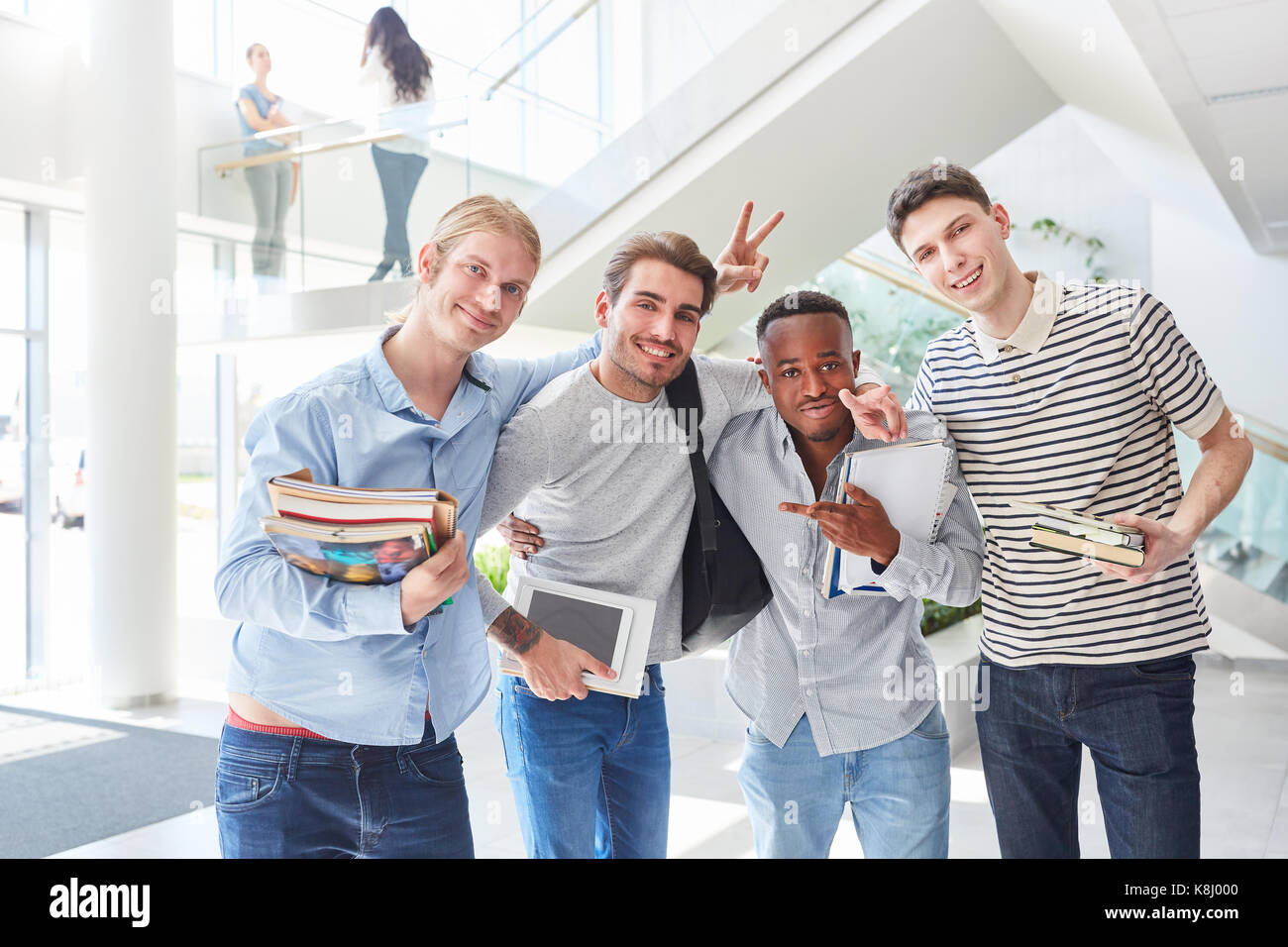 Felice e divertimento agli studenti come amici in un gruppo insieme in università Foto Stock