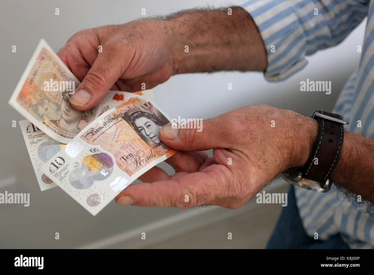 Un uomo nella foto tenendo un nuovo dieci pound nota nella sua casa a Chichester, west sussex, Regno Unito. Foto Stock