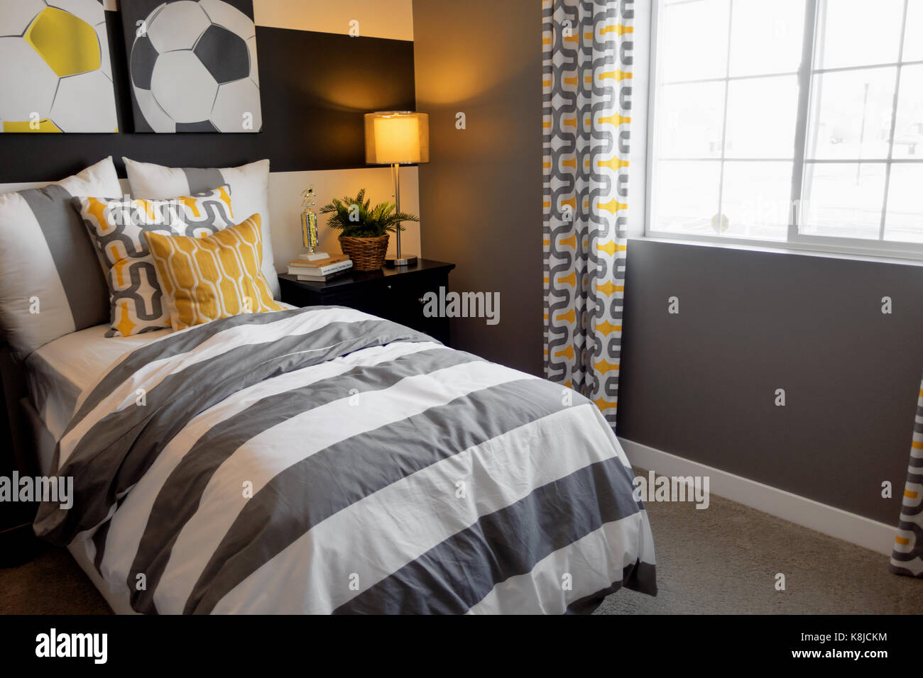 Un calcio decorate camera da letto con un letto singolo e comodini. Foto Stock