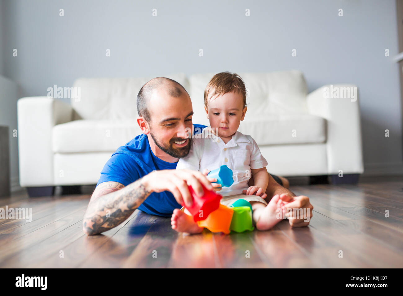 Padre Felice e piccolo figlio di giocare con blocchi giocattolo a casa Foto Stock