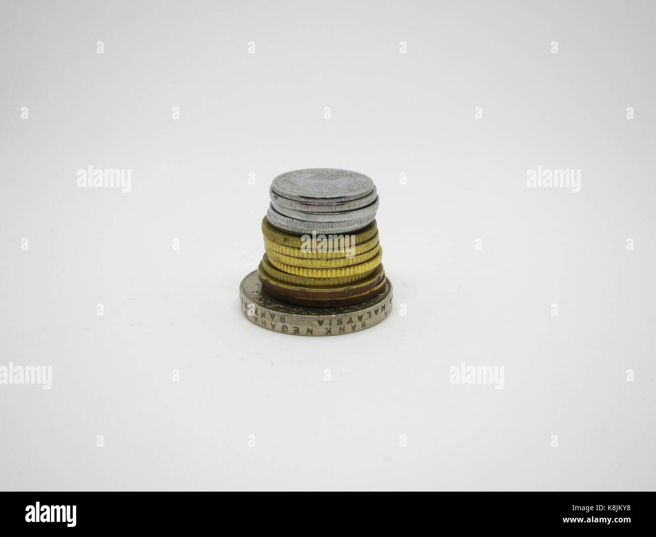 Monete malesi su uno sfondo bianco (messa a fuoco selettiva) Foto Stock