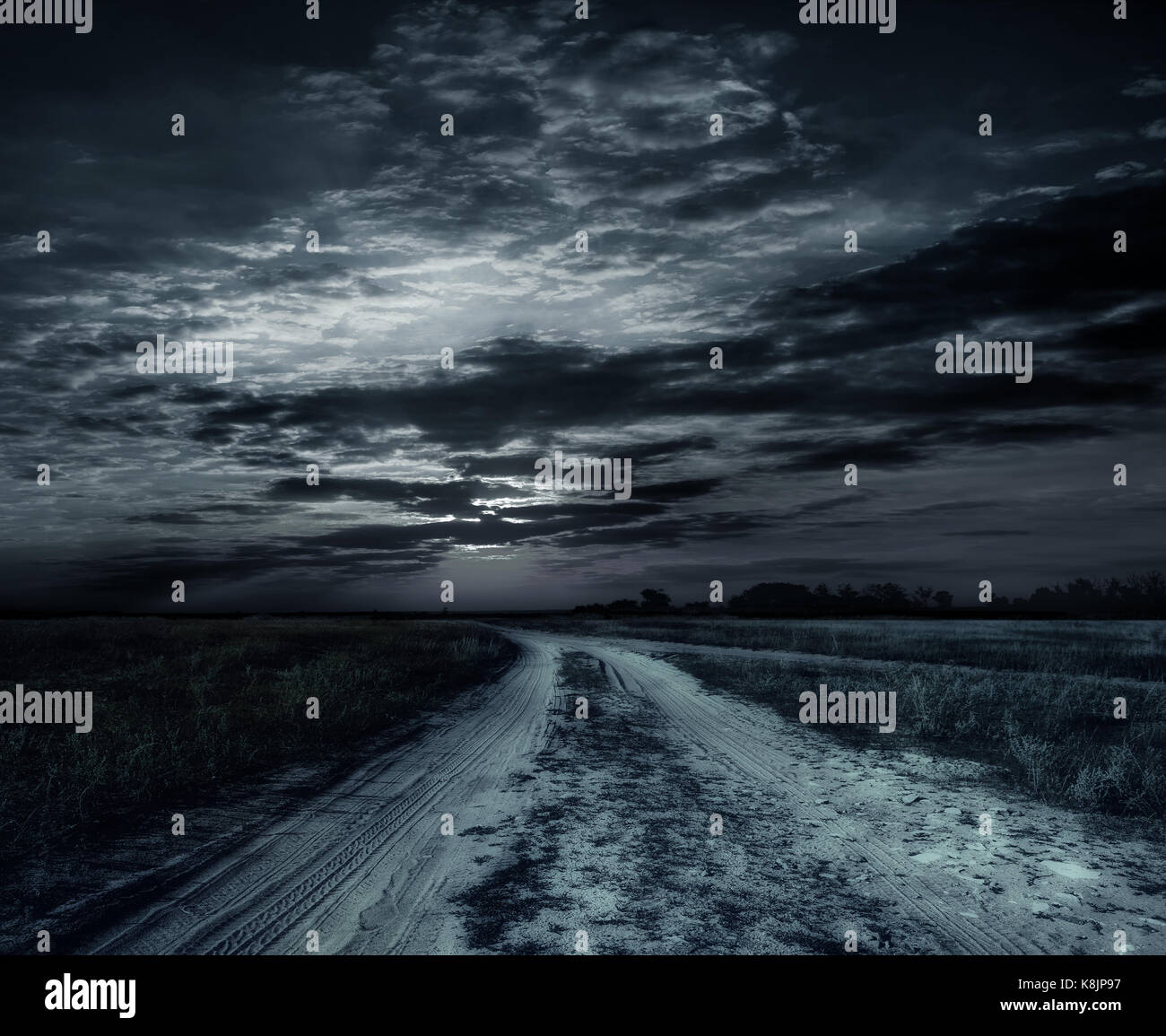 Strada di campagna di notte con grande luna Foto Stock