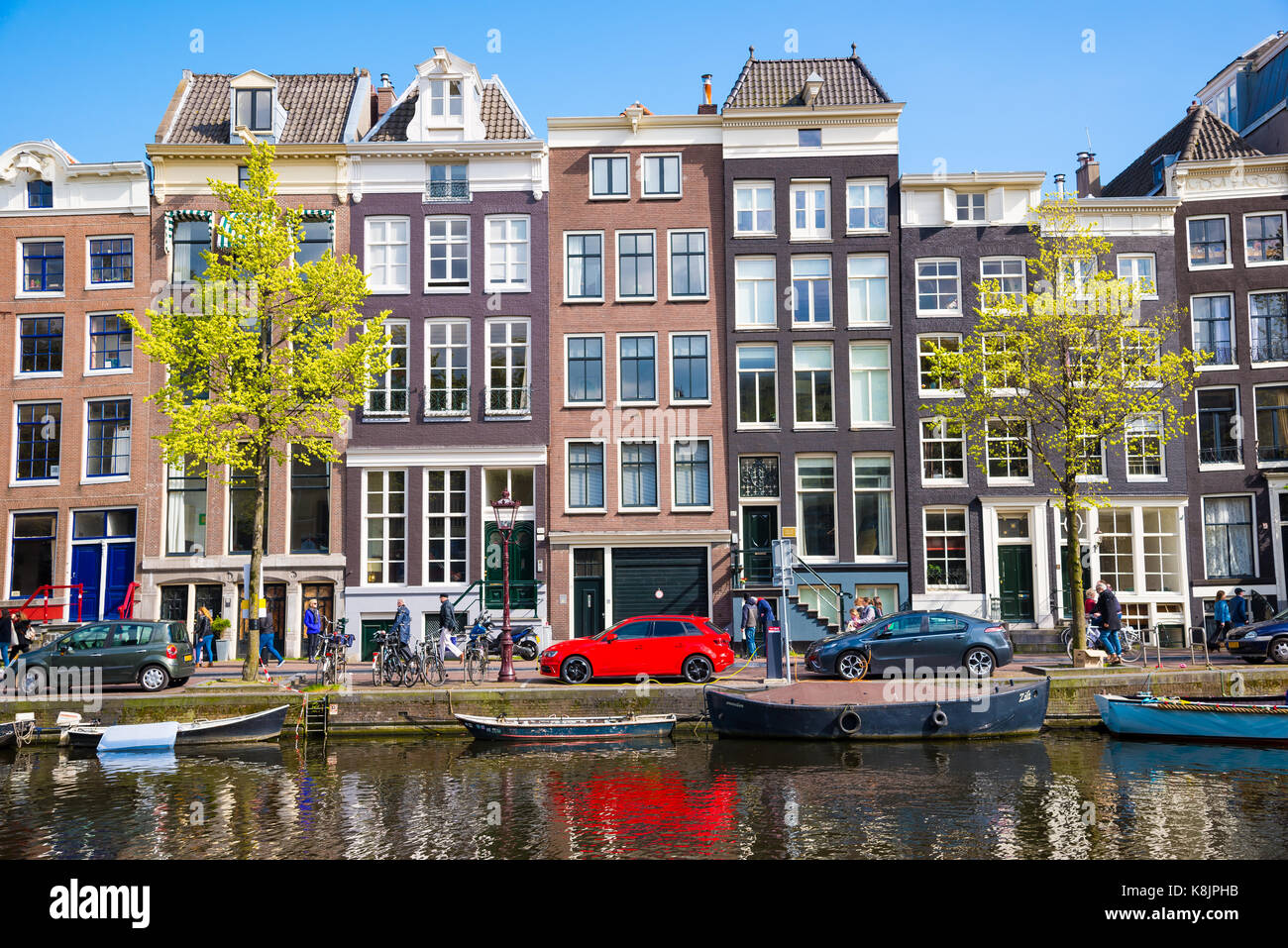 Amsterdam, Paesi Bassi - 19 Aprile 2017: Case colorate e le vetture lungo il canal terrapieno in Amsterdam, Paesi Bassi Foto Stock