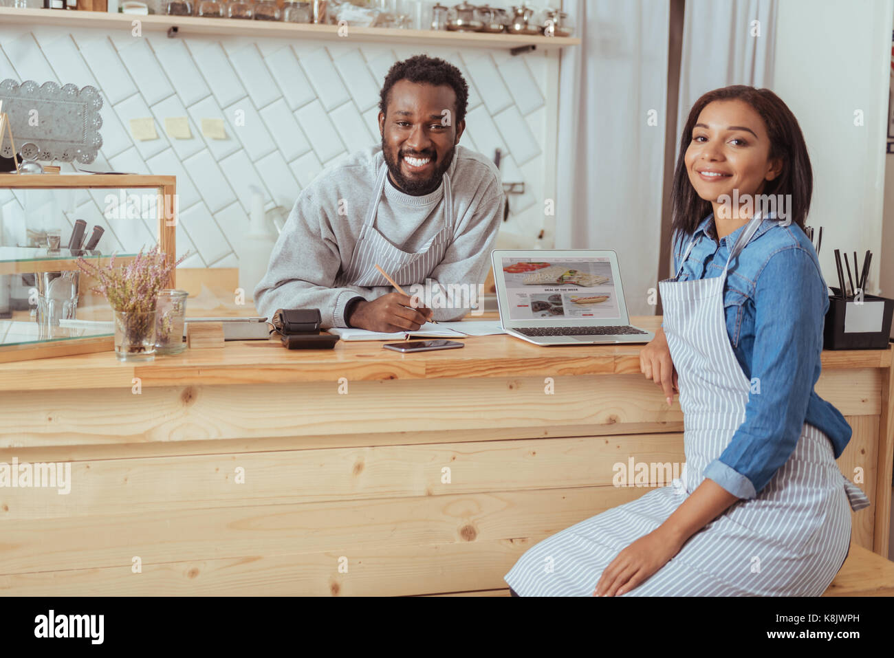Affascinante baristi in posa mentre discutete cafe sito web Foto Stock