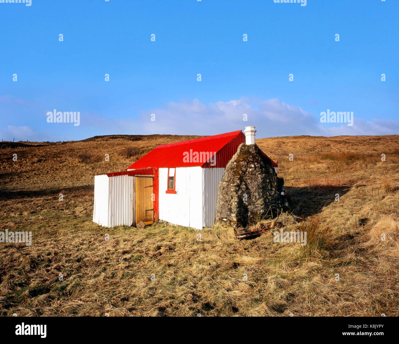 Un dipinto luminosamente crofters cottage apporta un tocco di colore al remote brughiere sull'isola di Skye nelle highlands scozzesi Foto Stock