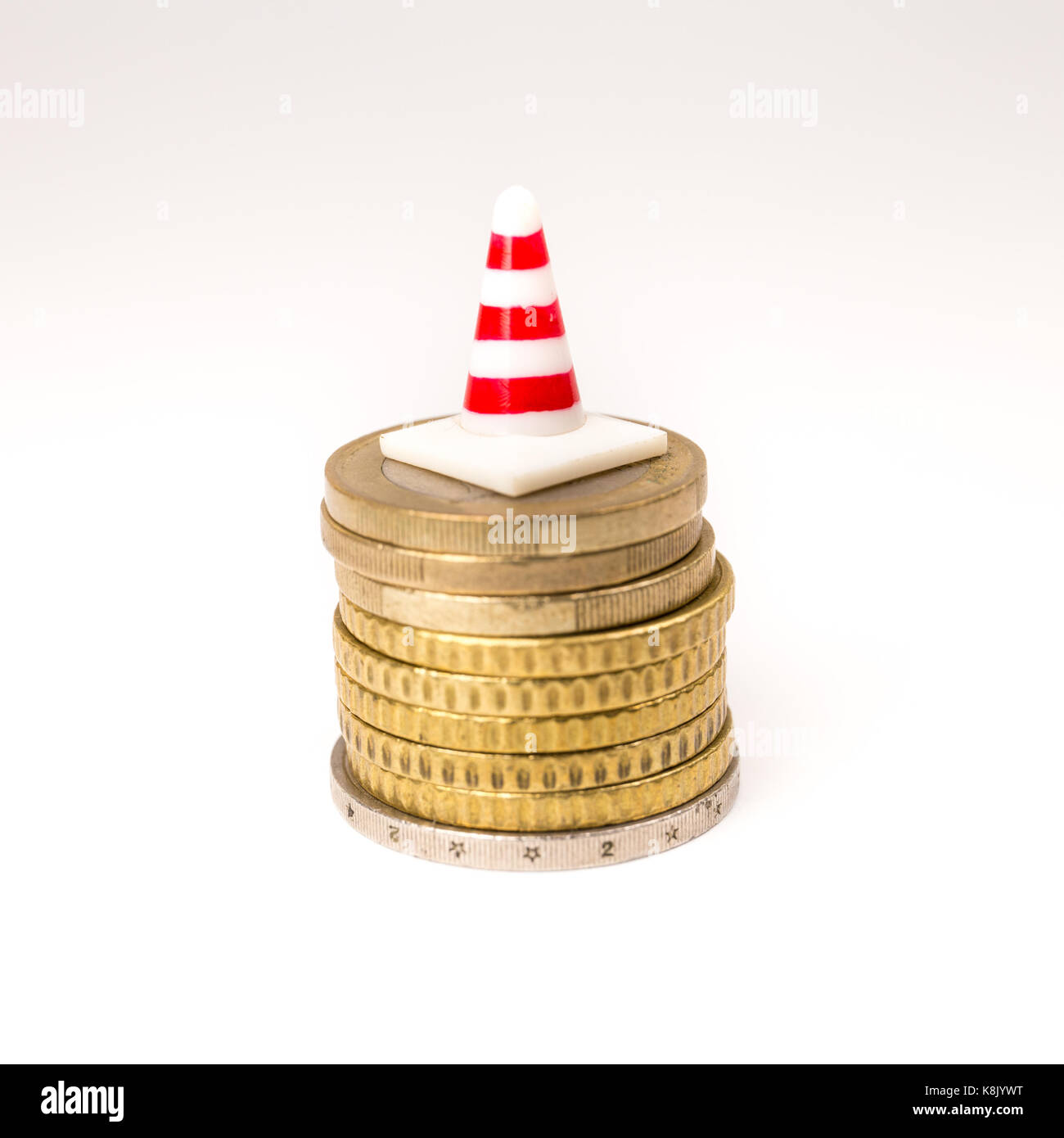 Il traffico in miniatura cono sulle monete in euro su sfondo bianco. salario, risparmi, Unione europea crisi economica concetto. Foto Stock