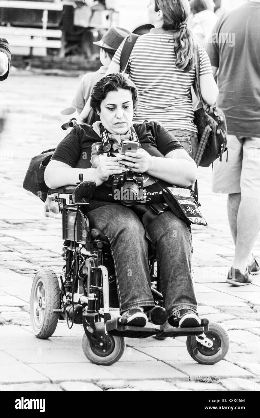 Donna disabile su sedia a rotelle utilizza lo smartphone Foto Stock