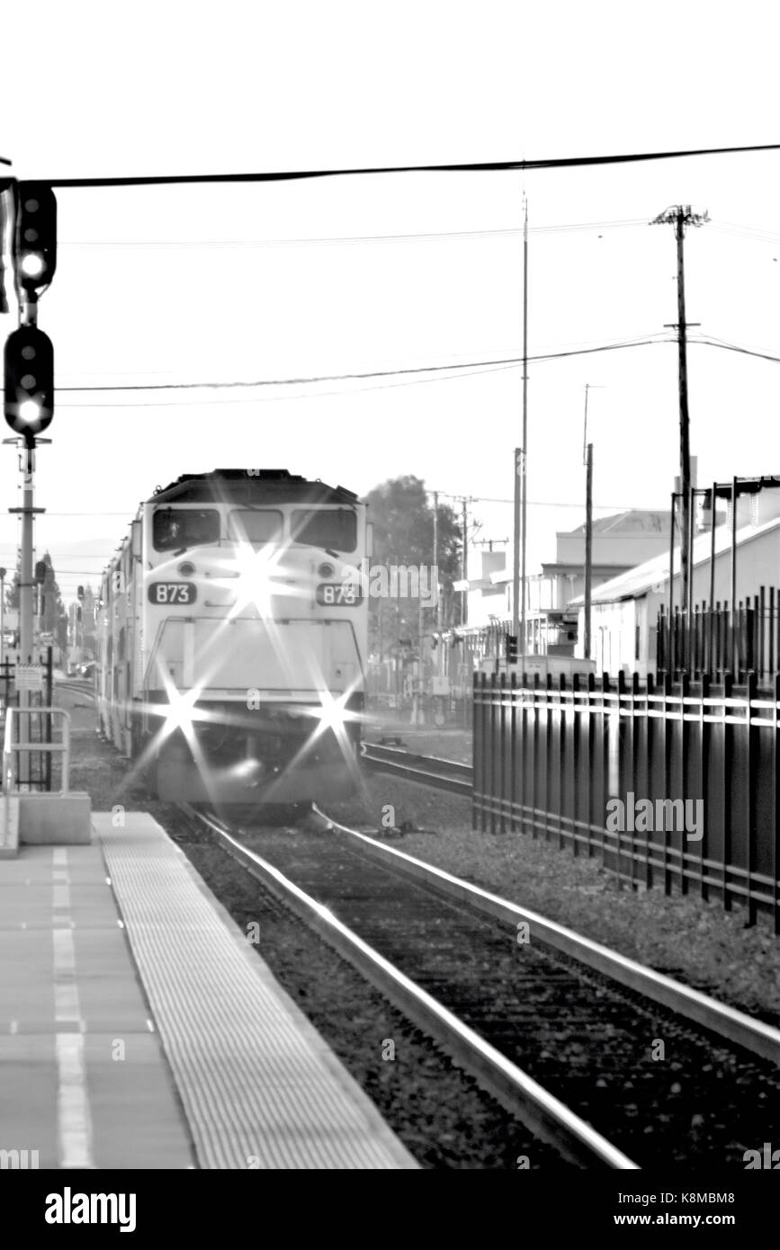 Bianco e nero immagine verticale del treno in avvicinamento a un trasporto urbano station Foto Stock
