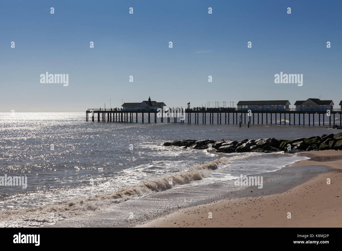 Southwold pier con la spiaggia e il mare in primo piano su un luminoso giorno di sole Foto Stock