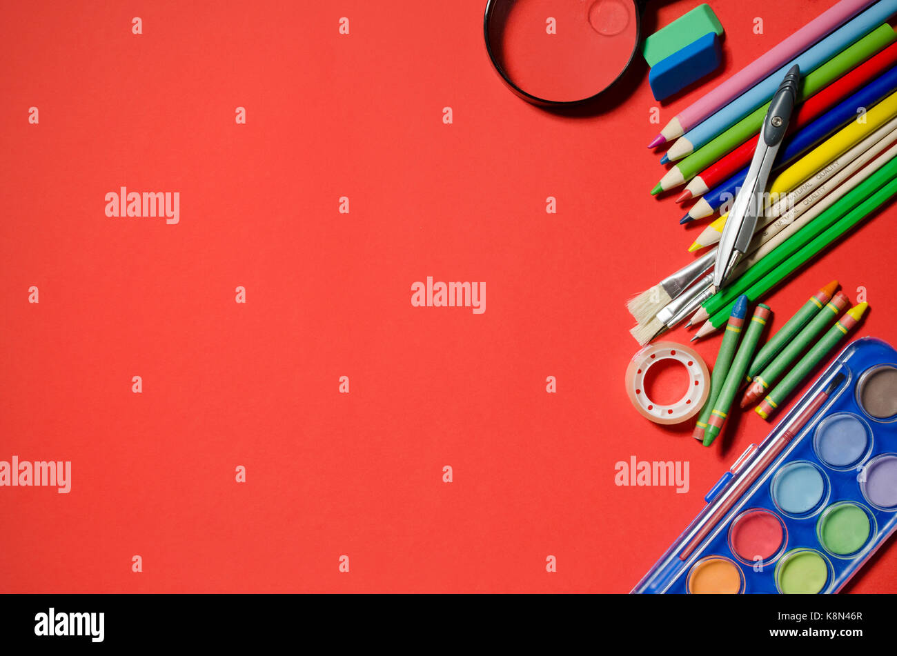 Scuola e articoli di cancelleria, sfondo rosso, copyspace. stationery office desk top visualizza tabella studente di scuola di concetto Foto Stock