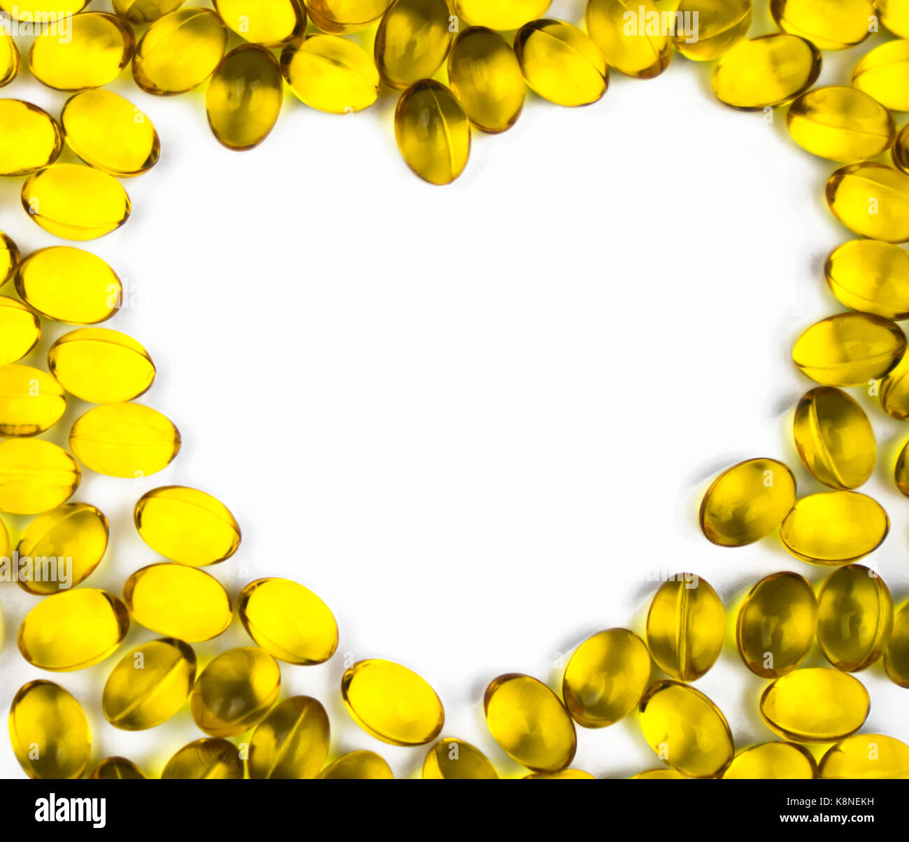 A forma di cuore di olio di fegato di merluzzo isolato su sfondo bianco con copia spazio. fonte di omega-3 (DHA+EPA) e vitamina A & D aiuta la crescita e lo sviluppo Foto Stock