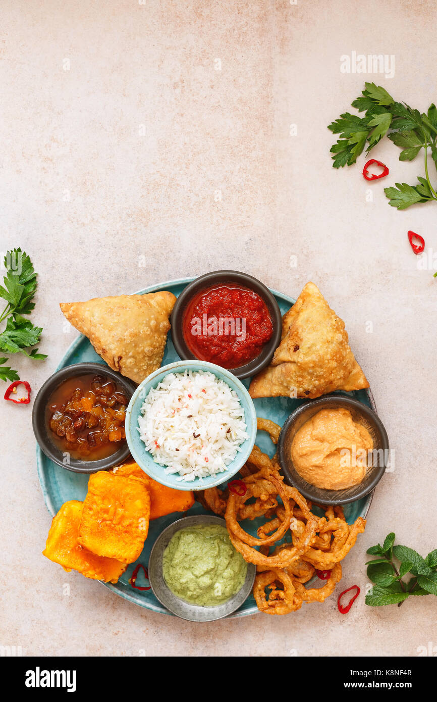 Indiano Vegetariano thali con riso jeera, vari snack e salse. vista dall'alto, uno spazio vuoto Foto Stock