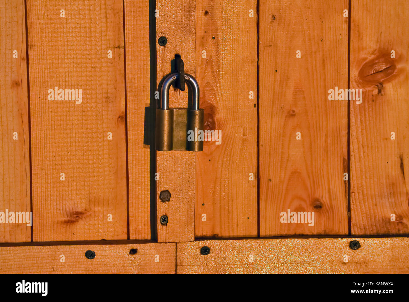 Primo piano del lucchetto su un rustico in legno porta Foto Stock