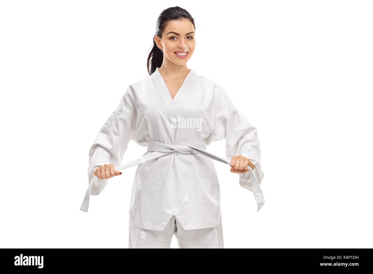 Giovane donna vestita di un kimono legatura di una cintura bianca attorno alla sua vita isolata su sfondo bianco Foto Stock