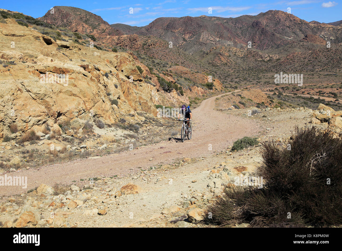 Persona in bicicletta nel Parco Nazionale Cabo de Gata, Monsul, nei pressi di San José, Almeria, Spagna Foto Stock