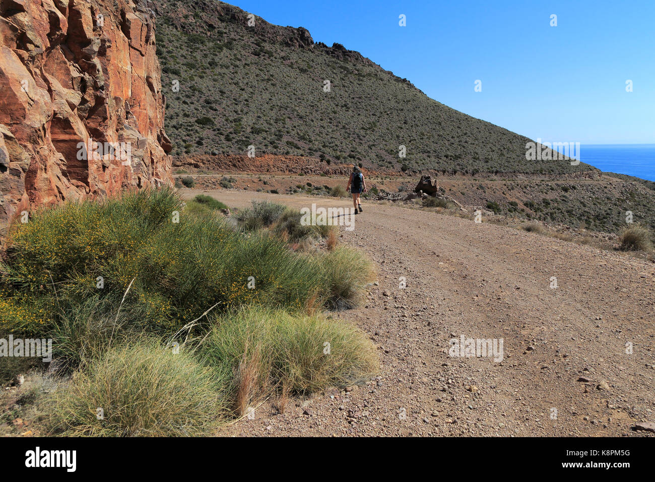 Donna camminando lungo il sentiero costiero nel Parco Nazionale Cabo de Gata, nei pressi di San José, Almeria, Spagna Foto Stock