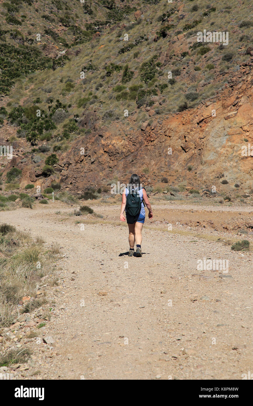Donna camminando lungo il sentiero costiero nel Parco Nazionale Cabo de Gata, nei pressi di San José, Almeria, Spagna Foto Stock