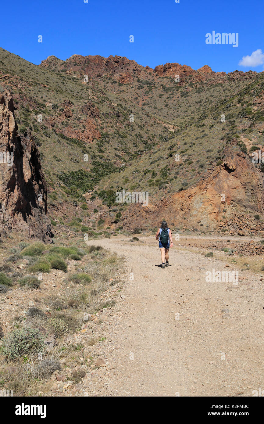 Donna camminando lungo il sentiero costiero nel Parco Nazionale Cabo de Gata, nei pressi di San José, Almeria, Spagna Foto Stock