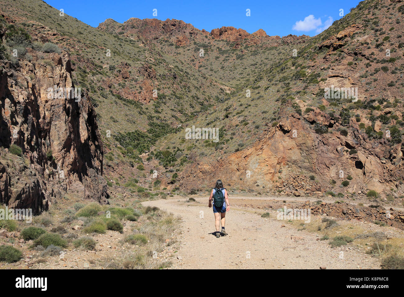 Donna camminando lungo il sentiero costiero nel Parco Nazionale Cabo de Gata, nei pressi di San José, Almeria, Spagna Foto Stock