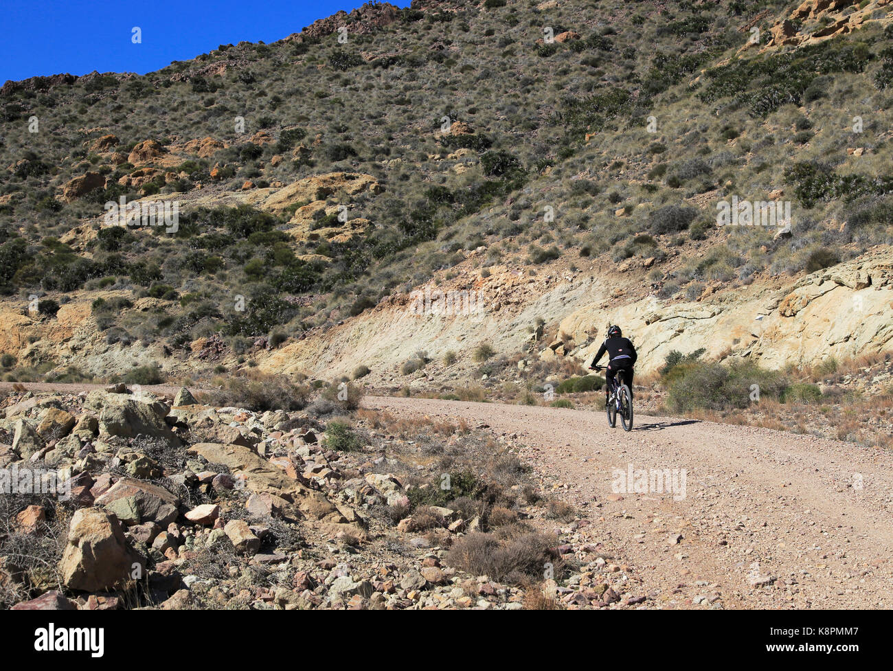 Persona in bicicletta nel Parco Nazionale Cabo de Gata, Monsul, nei pressi di San José, Almeria, Spagna Foto Stock
