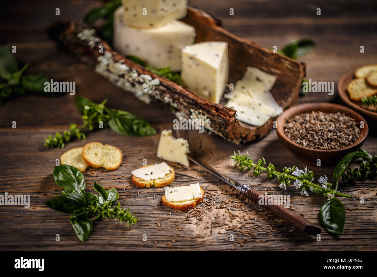 Ancora la vita di formaggio con semi di cumino sulla corteccia Foto Stock