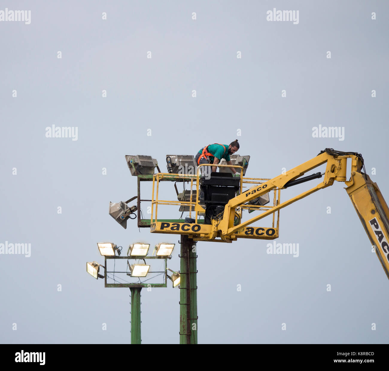 Lavoratore controllando il campo di calcio di proiettori da cherry picker in Spagna Foto Stock