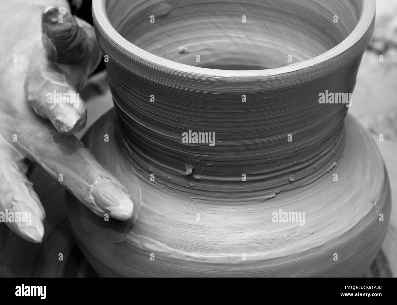 Processo per la fabbricazione di piatti sul wheel. di un vasaio vasaio al lavoro. in bianco e nero tonica. Foto Stock