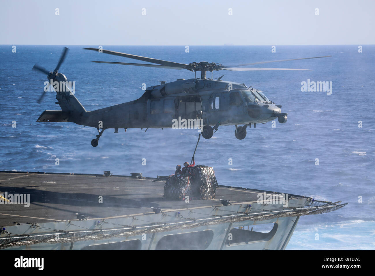 Un U.S. Navy MH-60S Seahawk con elicottero mare squadrone di combattimento (HSC) 28 prende le forniture dal USNS alimentazione (T AOE 6) alla USS Iwo Jima (LHD 7) Foto Stock