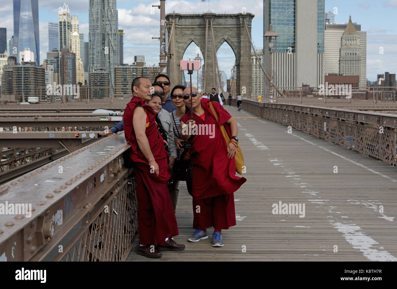 New York, NY, Stati Uniti d'America - 3 Maggio 2017: il gruppo dei popoli asiatici e dei monaci buddisti in vesti tradizionali prendere un selfy foto sul ponte di Brooklyn. Foto Stock