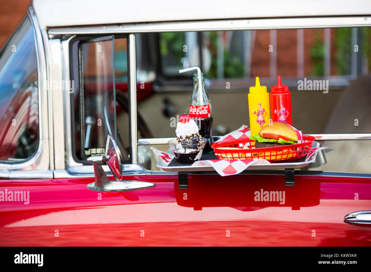 Il fast food menu su un vassoio su porta di cadillilac classic car. Credito: Christian lademann Foto Stock