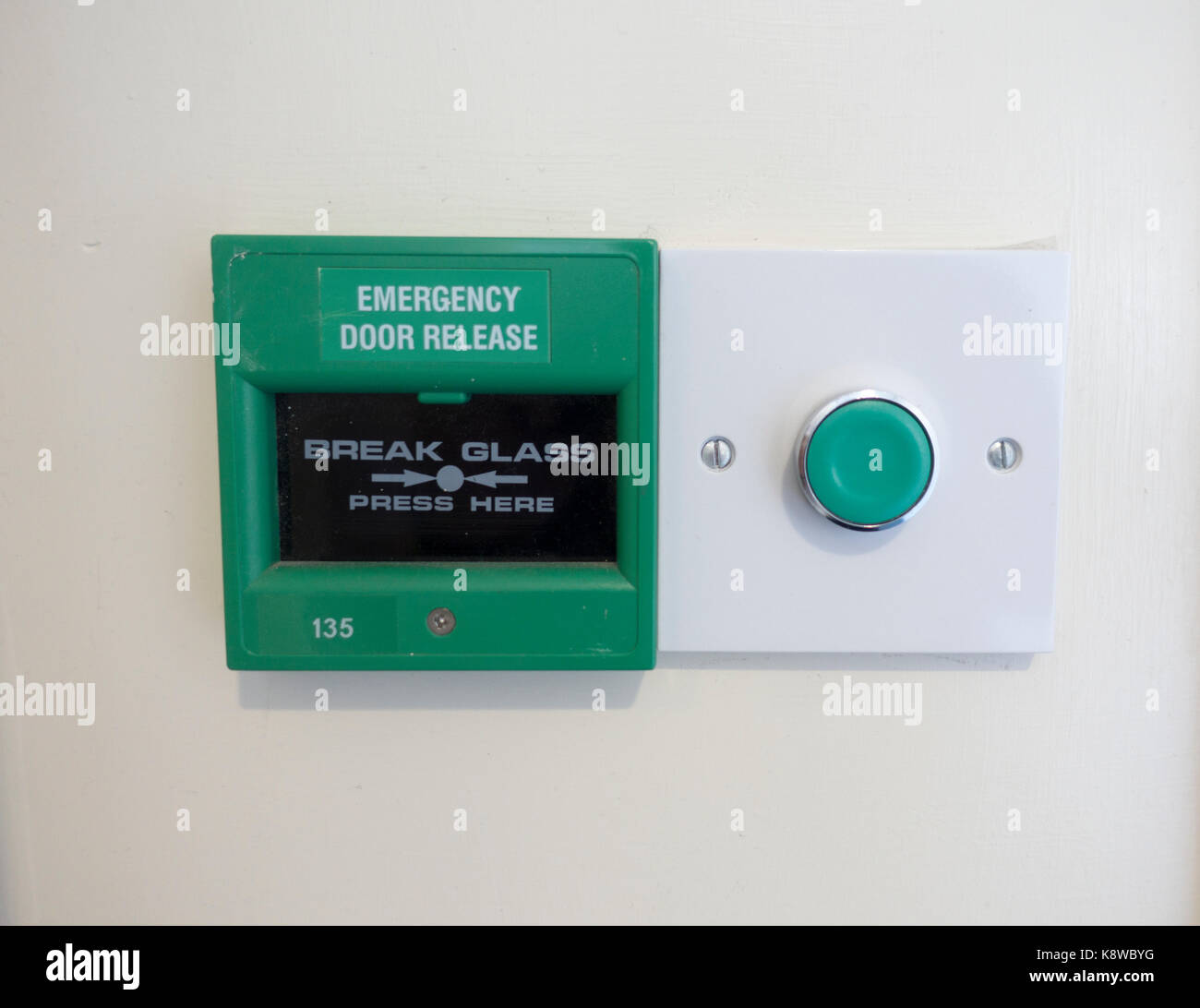 Porta di emergenza rilasciare il pulsante e rompere il pannello di vetro su una parete Foto Stock