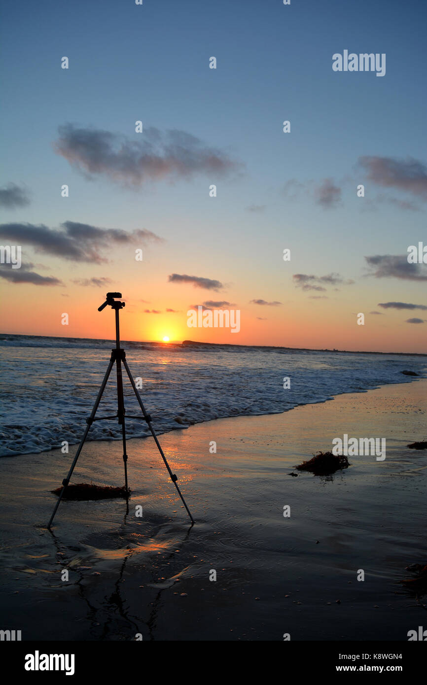 Un treppiede sulla spiaggia al tramonto Foto Stock