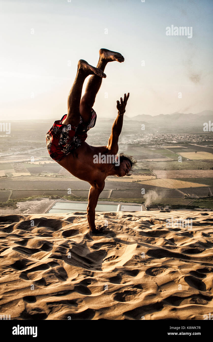 Adulto Uomo peruviano praticando capoeira sulla duna Huamanchacate. Coishco, Dipartimento di Ancash, Perù. Foto Stock