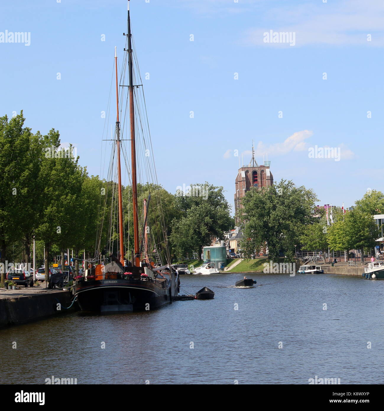 Velieri tradizionali ormeggiate lungo Westersingel canal nel centro di Leeuwarden, Friesland, Paesi Bassi. Sullo sfondo iconico Oldehove torre. Foto Stock