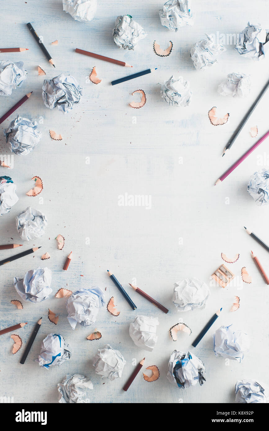 Copia del cerchio di spazio con un telaio di carta sgualcita di sfere e matite su un bianco sullo sfondo di legno, scrittura creativa del concetto. Foto Stock