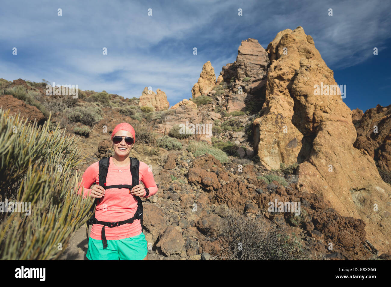 Felice ragazza escursionista camminando sul sentiero di montagna. Ispirare e motivare il concetto di attività all'aperto. Runner scalatore o guardando a terra ispiratrice Foto Stock