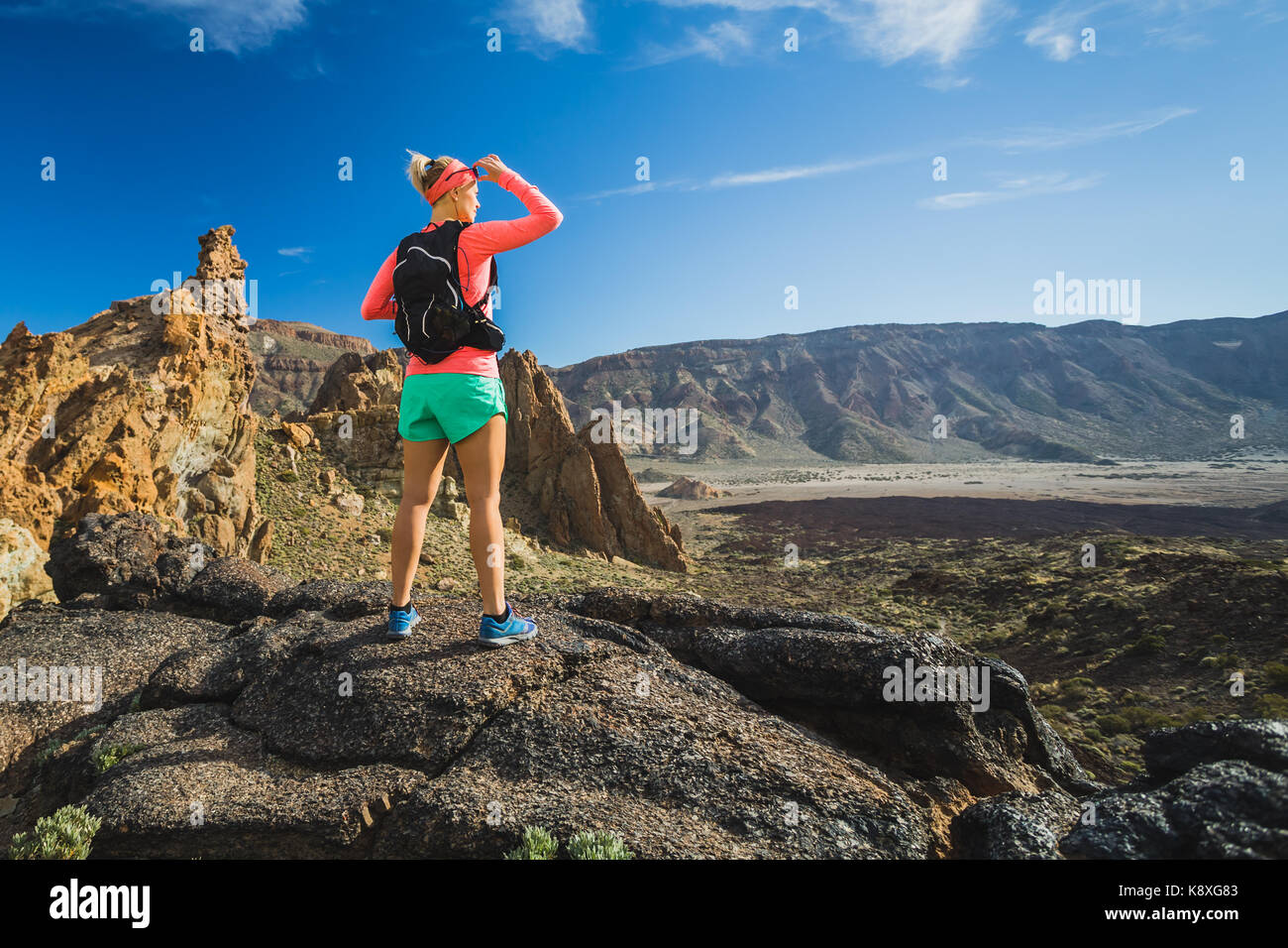 La donna ha raggiunto degli escursionisti di montagna. Ispirare e motivare il concetto di attività all'aperto. Runner scalatore o guardando il paesaggio di ispirazione su r Foto Stock