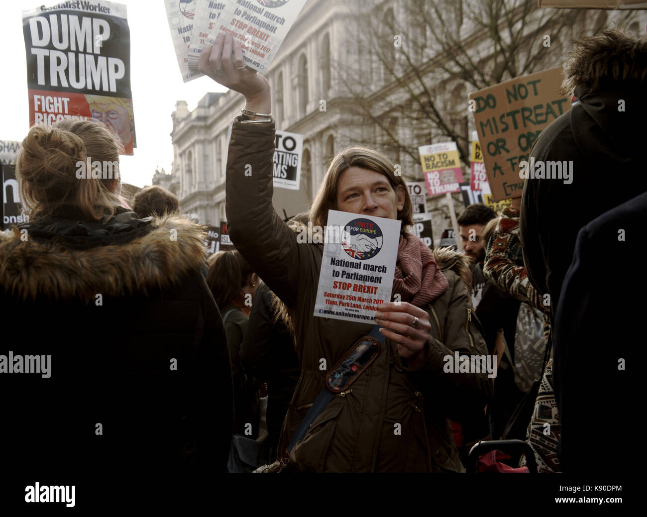Una donna può contenere un massimo di volantini per informare la folla di una demo nazionale contro brexit in una dimostrazione intorno al trump il divieto di viaggio. Foto Stock