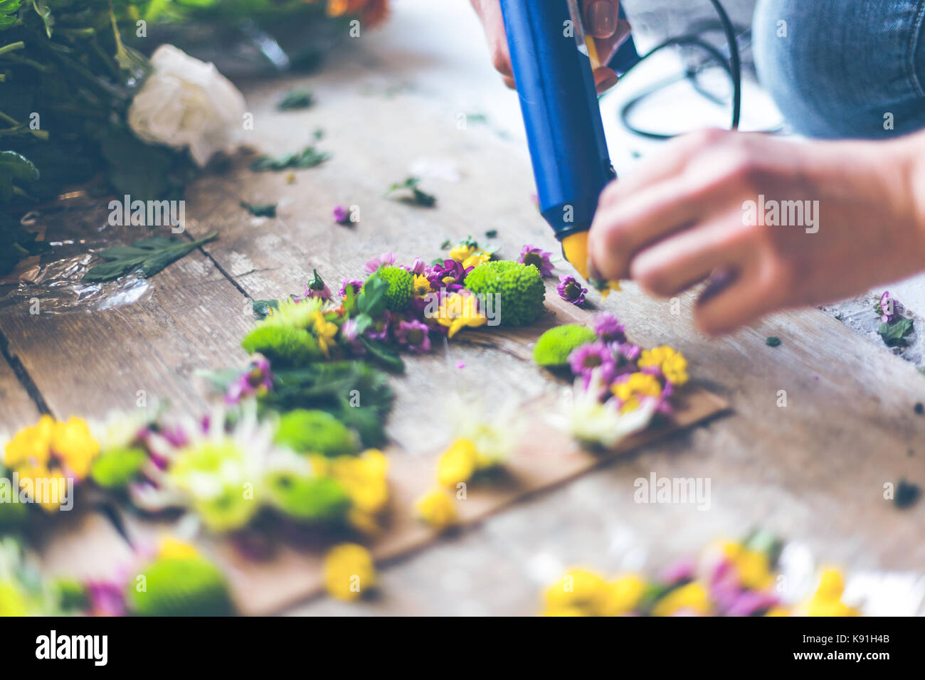 Fioraio effettuare decorazioni di fiori con lettere e colla. in interni luce naturale shot con piccole profondità di campo Foto Stock