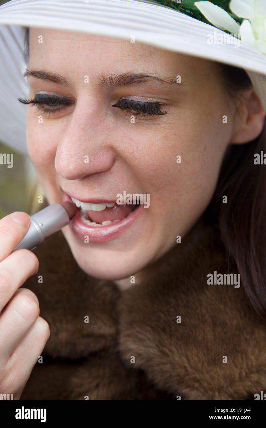 Donna in Furs che applica il rossetto Foto Stock