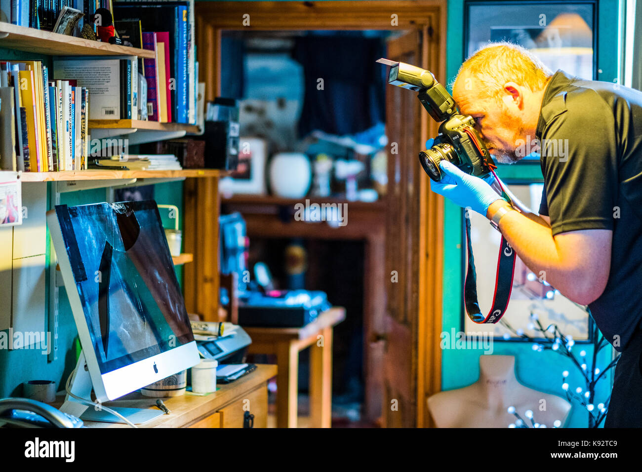 Una scena di polizia di criminalità officer (soco) in una casa a lavorare la verifica di un danneggiato imac 27' computer per le impronte digitali da sinistra di ladri, Regno Unito Foto Stock Una scena di polizia di criminalità officer (soco) in una casa a lavorare la verifica di un danneggiato imac 27' computer per le impronte digitali da sinistra di ladri, Regno Unito Foto Stock