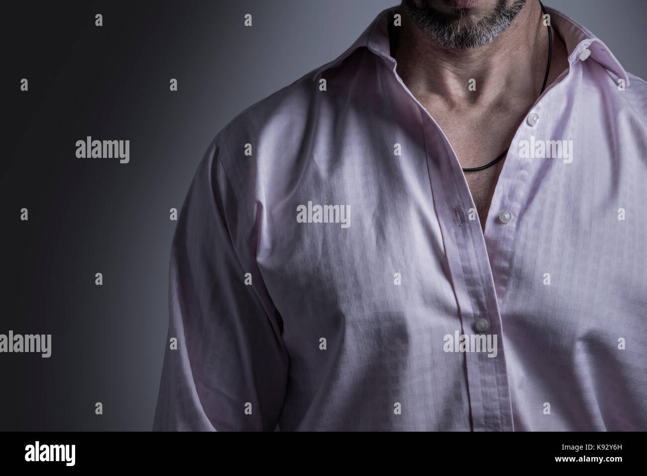 Uomo Barbuto che indossa una camicia rosa e filo nero collana Foto stock -  Alamy